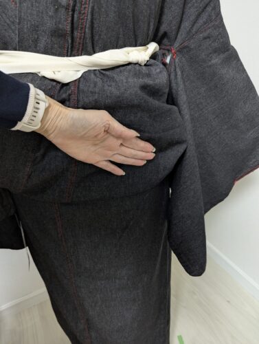 胸紐を締めてから隙間から手を入れて、下前を折り上げている